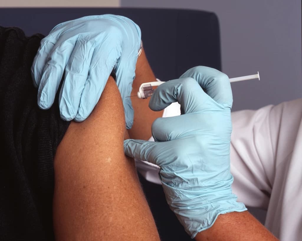 Close-up of a vaccine being administered into an upper arm
